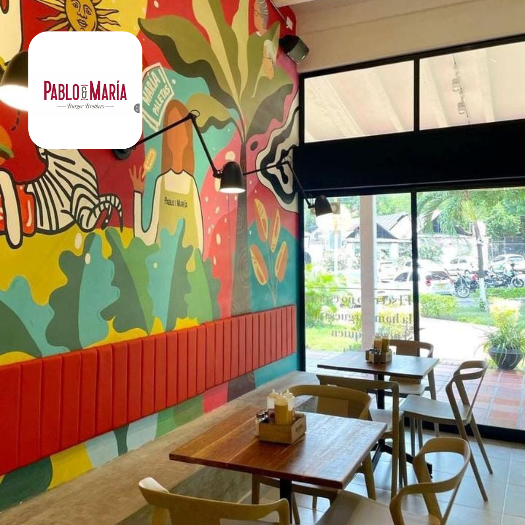 Imagen de restaurante con mesas y sillas y pared con grafitis