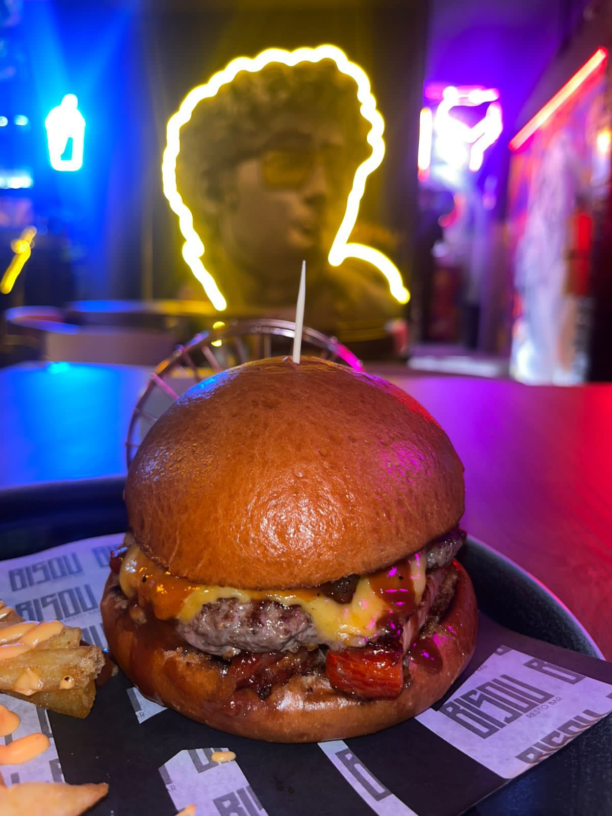 Restaurante con hamburguesa mural de hombre con luces neón