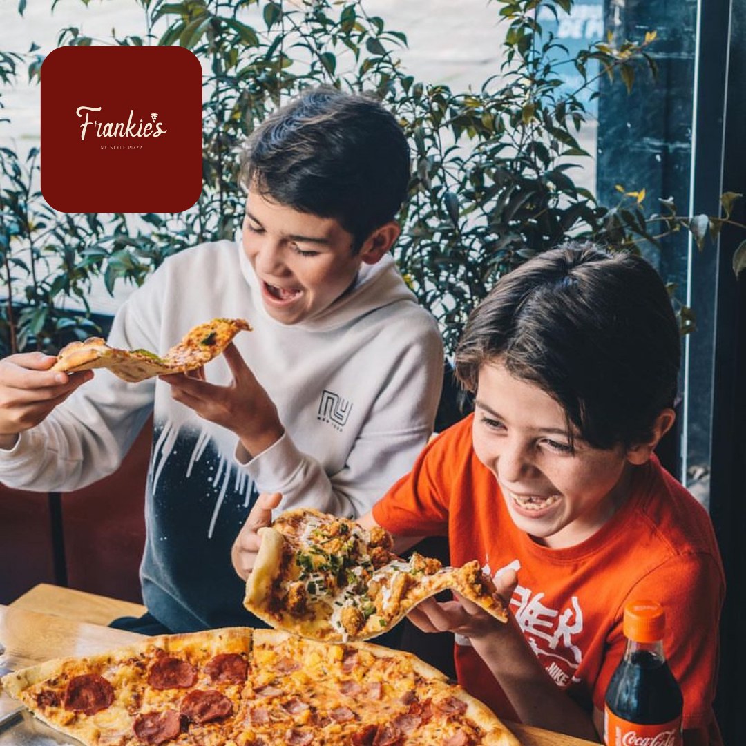 Restaurante con niños comiendo pizza 